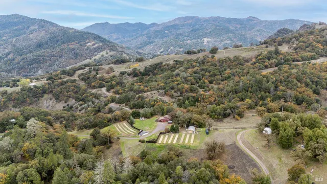 an aerial view of mountains residential house and green space