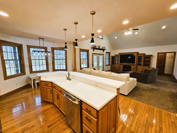 a large white kitchen with a large center island and stainless steel appliances