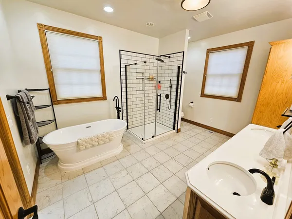 a bathroom with a tub sink and mirror