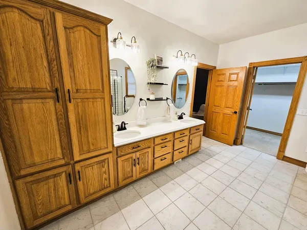 a spacious bathroom with a double vanity sink and a mirror