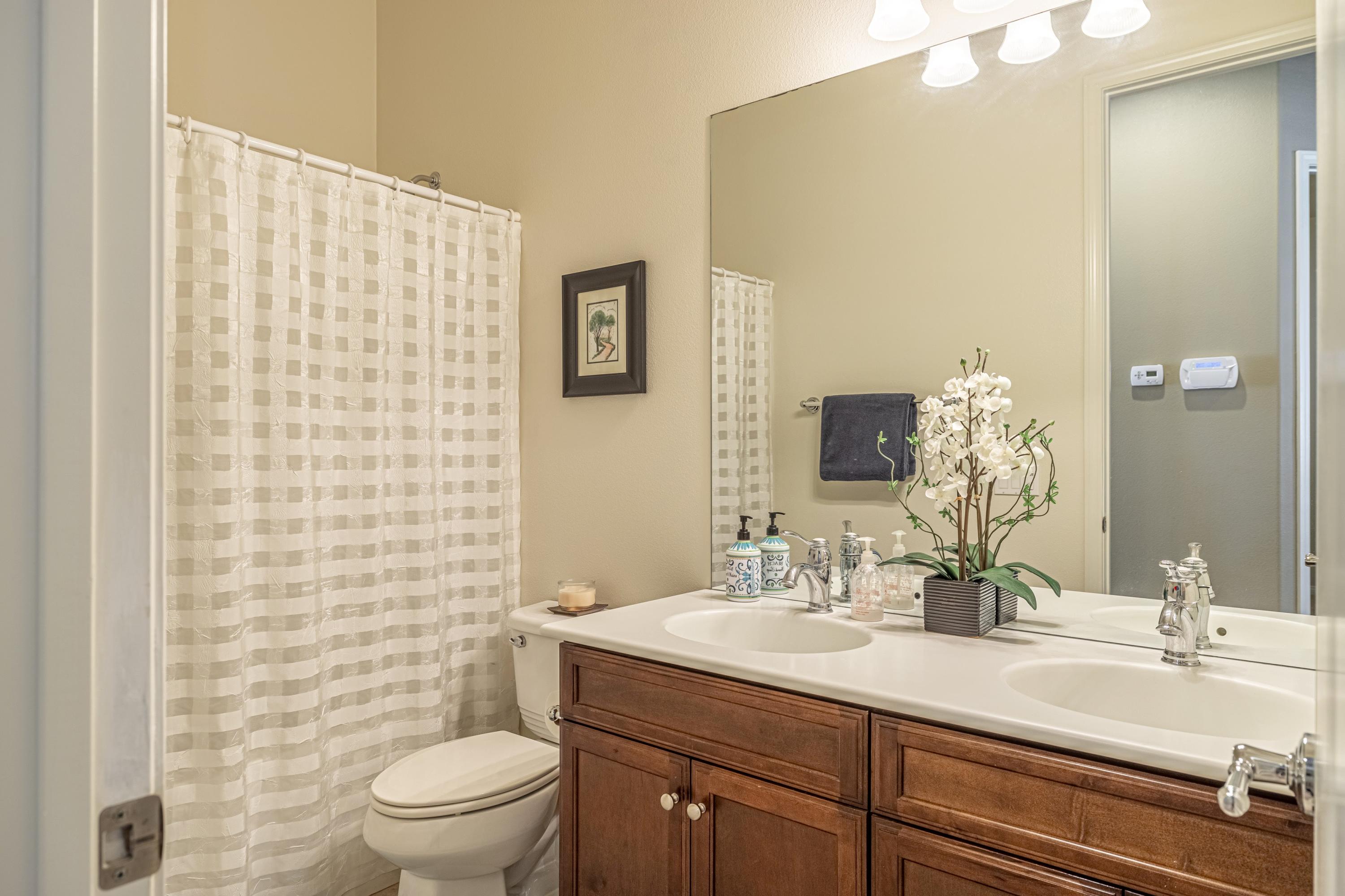 6853 Cabernet Road Palmdale, CA 93551 - Photo 22 of 42 a bathroom with a sink a toilet and shower curtain