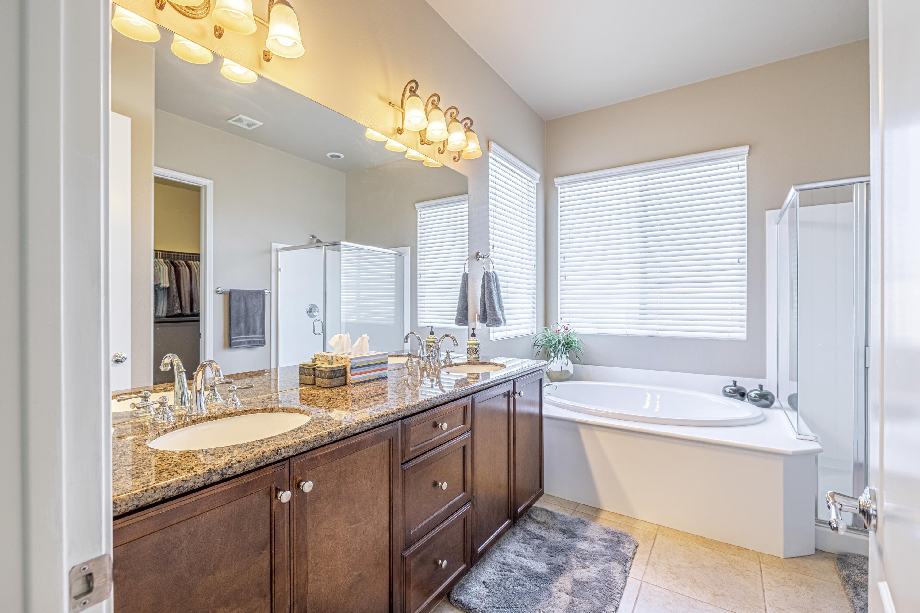 6853 Cabernet Road Palmdale, CA 93551 - Photo 34 of 42 a bathroom with a double vanity sink large mirror and a bathtub