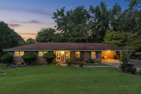a front view of a house with a garden and yard