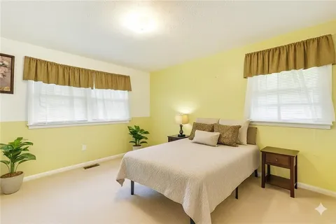 a bedroom with a bed and a potted plant