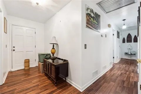 a view of a hallway with wooden floor and bathroom