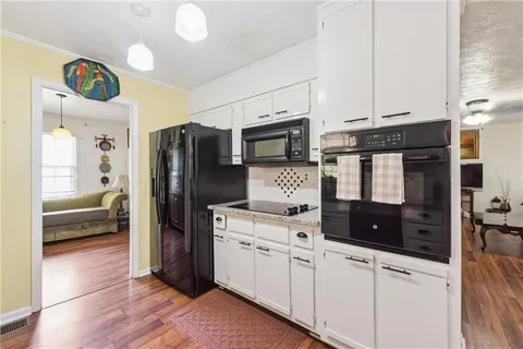 a kitchen with stainless steel appliances a refrigerator a stove and white cabinets