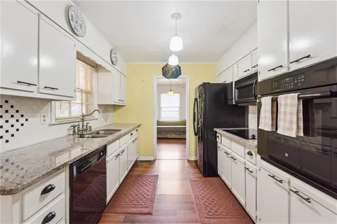 a kitchen with stainless steel appliances granite countertop a sink and a refrigerator