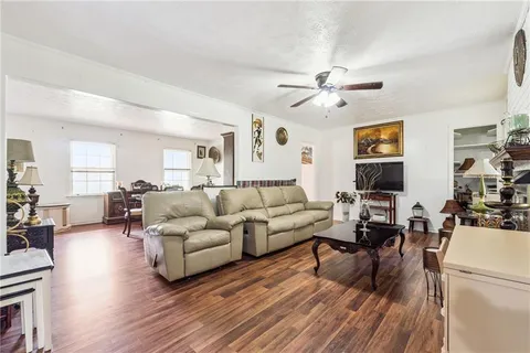 a living room with furniture and a wooden floor