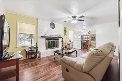 a living room with couches a fireplace with wooden floor
