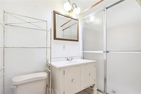 a bathroom with a toilet sink vanity and mirror