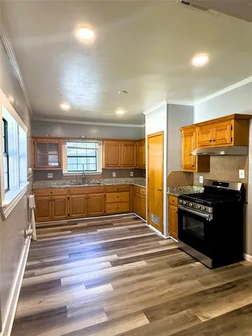 a view of an empty room and a kitchen