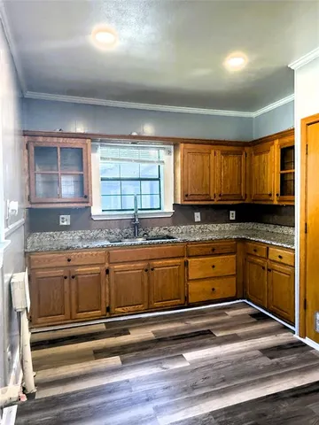 a kitchen with wooden floors and stainless steel appliances