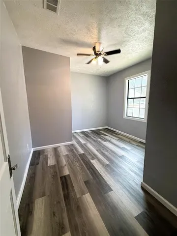 a view of a livingroom with a ceiling fan and wooden floor