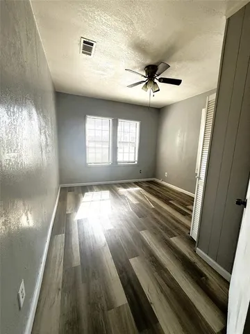 a view of a livingroom with wooden floor and a ceiling fan