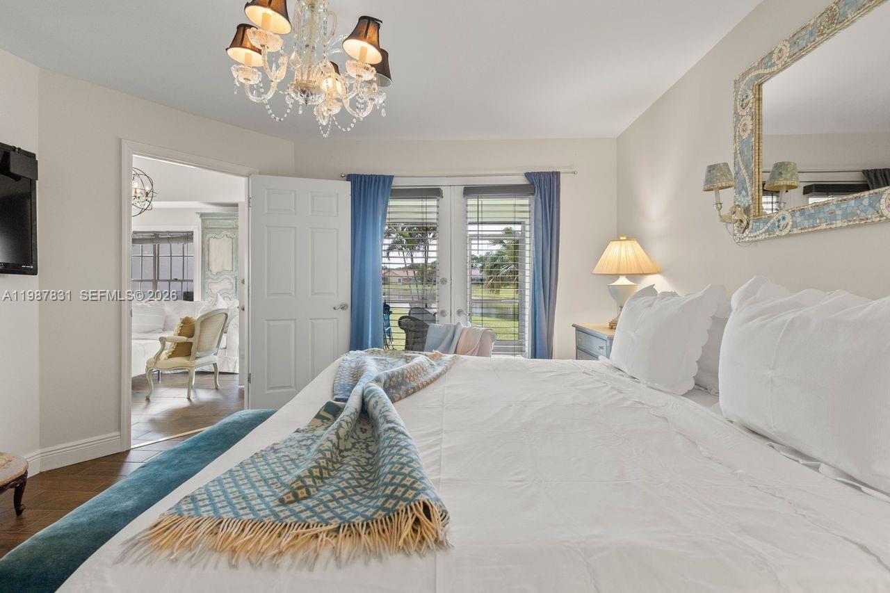 18551 Woodstream Drive Boca Raton, FL 33498 - Photo 19 of 27 a bed sitting in a bedroom and chandelier