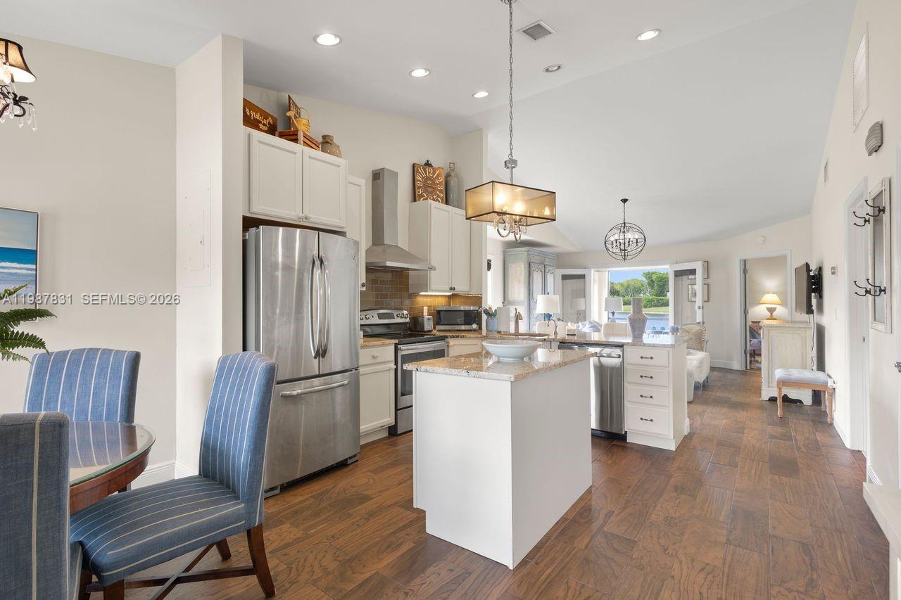 18551 Woodstream Drive Boca Raton, FL 33498 - Photo 3 of 27 an open kitchen with white cabinets and stainless steel appliances