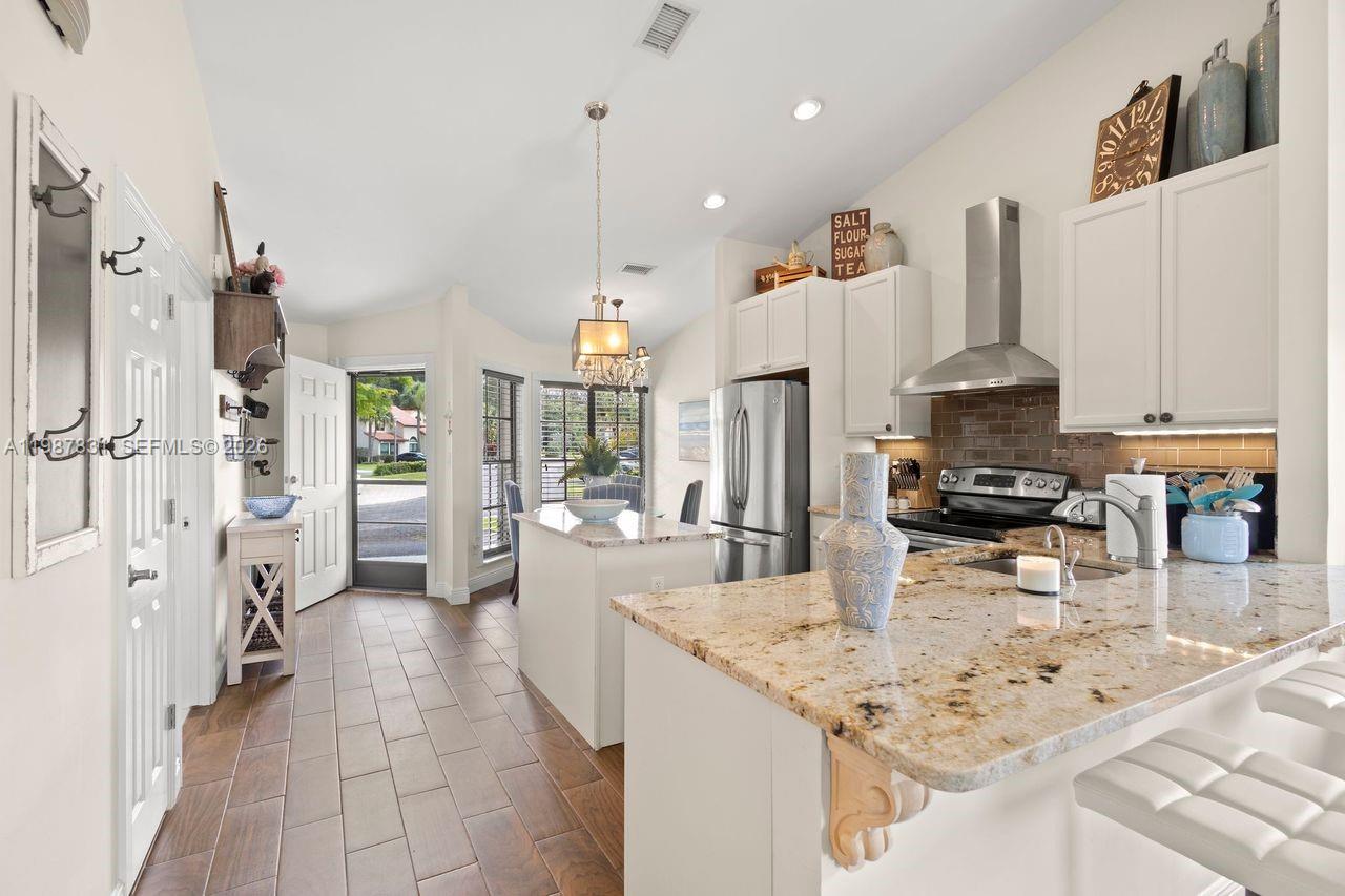 18551 Woodstream Drive Boca Raton, FL 33498 - Photo 5 of 27 a kitchen with stainless steel appliances kitchen island granite countertop a sink and cabinets