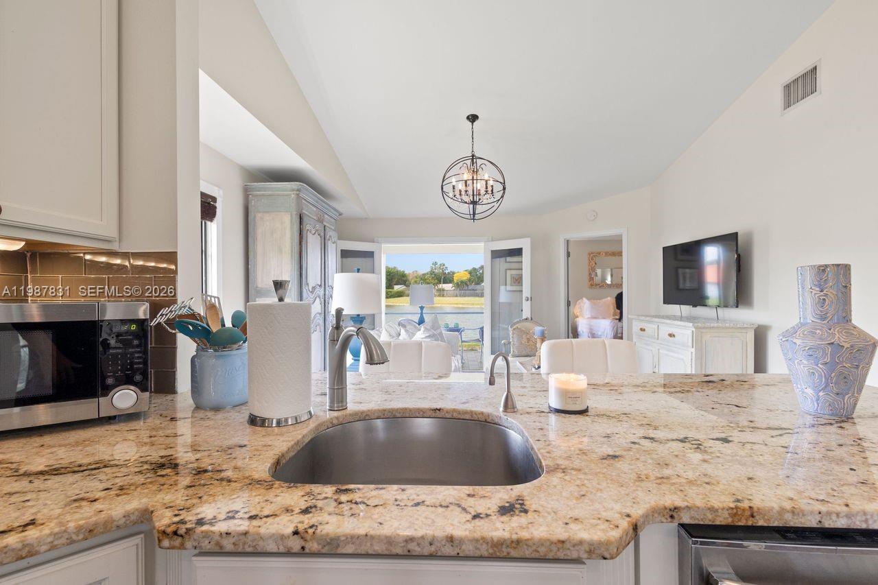 18551 Woodstream Drive Boca Raton, FL 33498 - Photo 6 of 27 a kitchen with stainless steel appliances granite countertop a stove and a sink with granite countertops