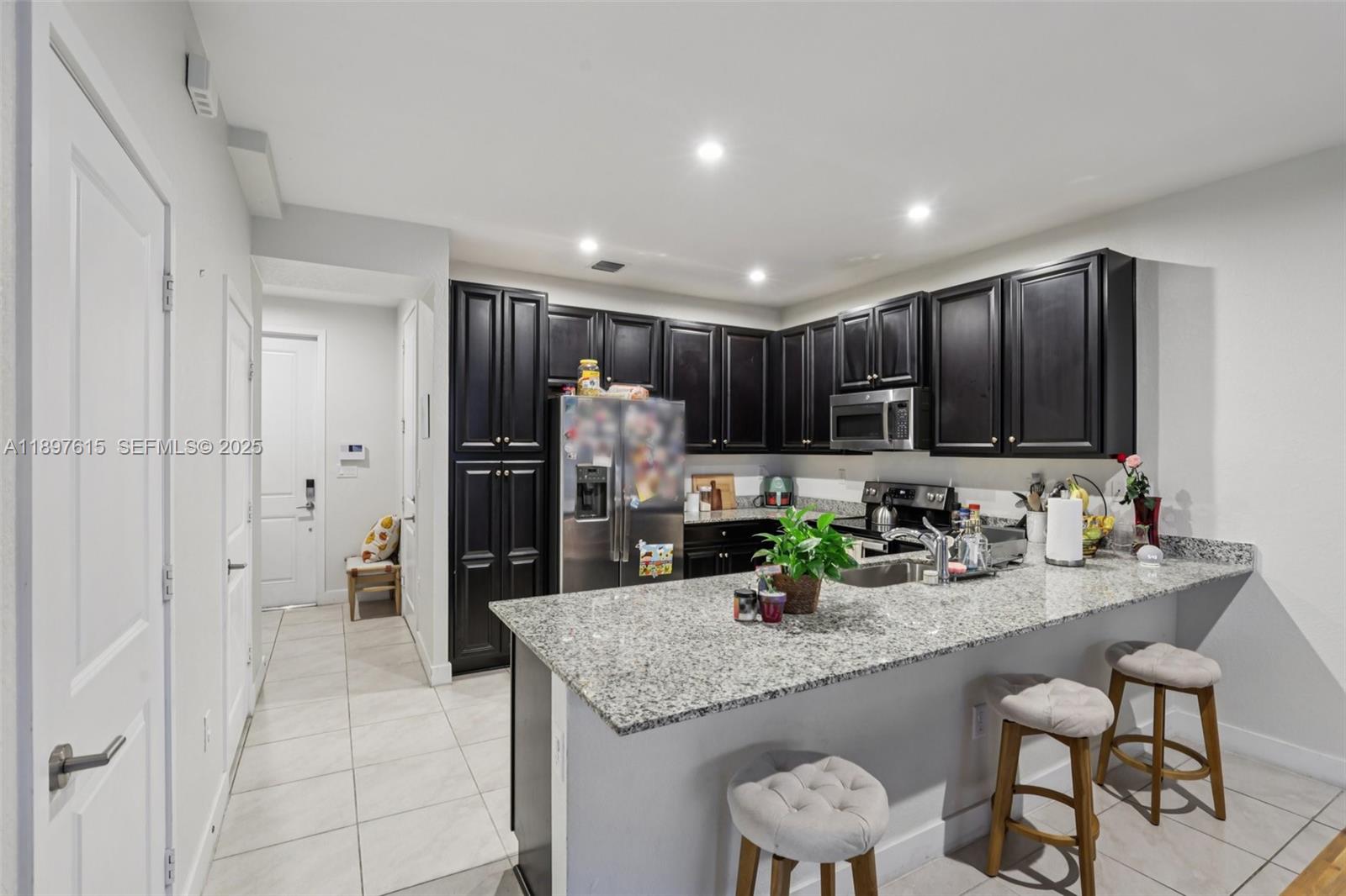 23291 Southwest 110th Court Homestead, FL 33032 - Photo 14 of 41 a kitchen with granite countertop cabinets and refrigerator