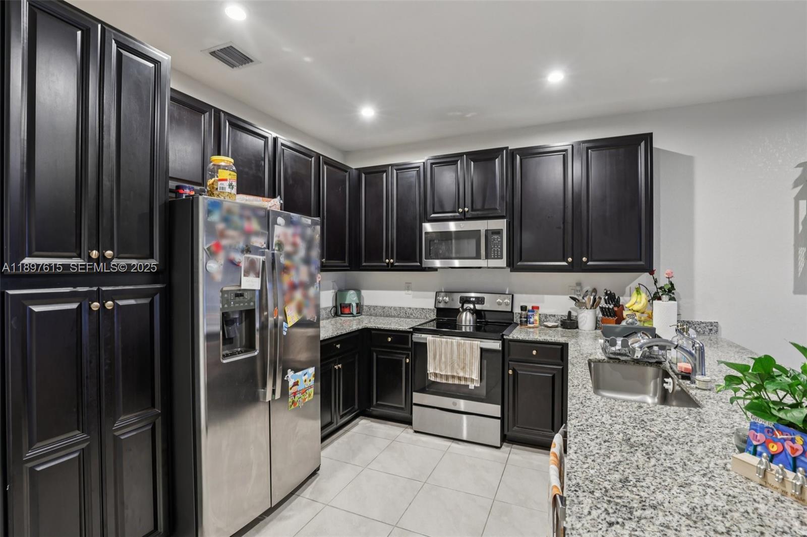 23291 Southwest 110th Court Homestead, FL 33032 - Photo 15 of 41 a kitchen with stainless steel appliances granite countertop a refrigerator stove and oven