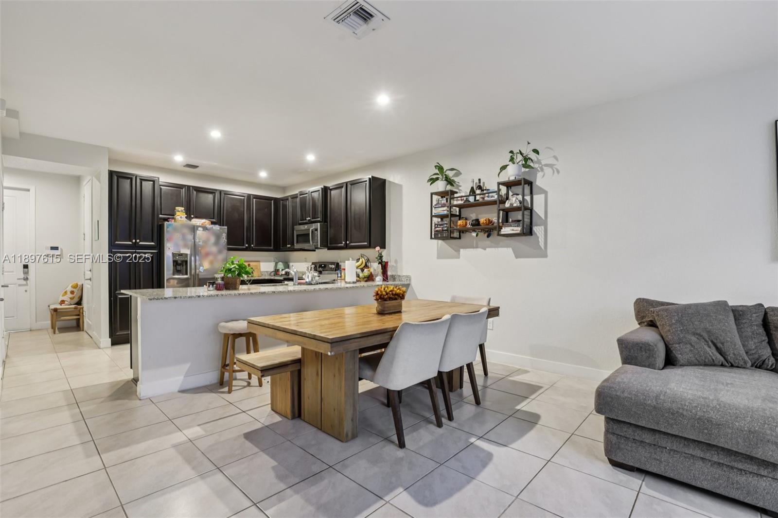 23291 Southwest 110th Court Homestead, FL 33032 - Photo 10 of 41 a kitchen with stainless steel appliances kitchen island granite countertop a sink and a refrigerator
