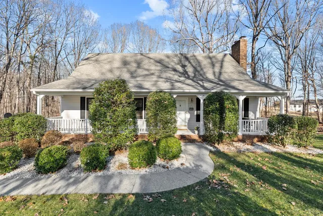 a front view of a house with a yard and potted plants