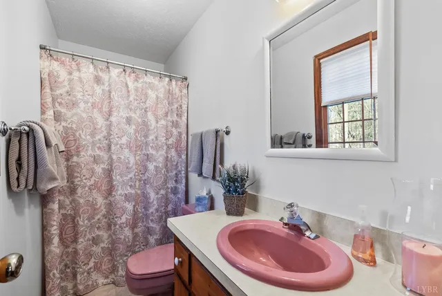 a bathroom with a sink toilet and a mirror