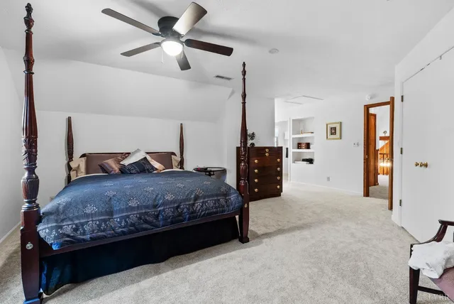 a spacious bedroom with a bed and ceiling fan