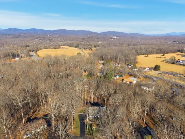 an aerial view of house with yard and mountain view in back