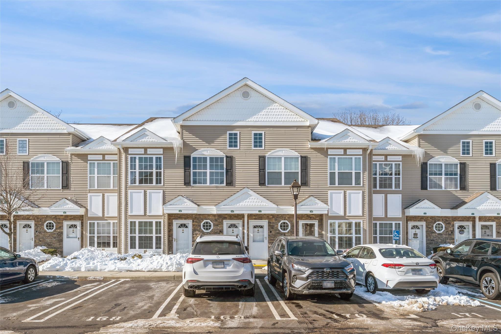 169 Spring Drive East Meadow, NY 11554 - Photo 3 of 33 a front view of a residential apartment building with a yard
