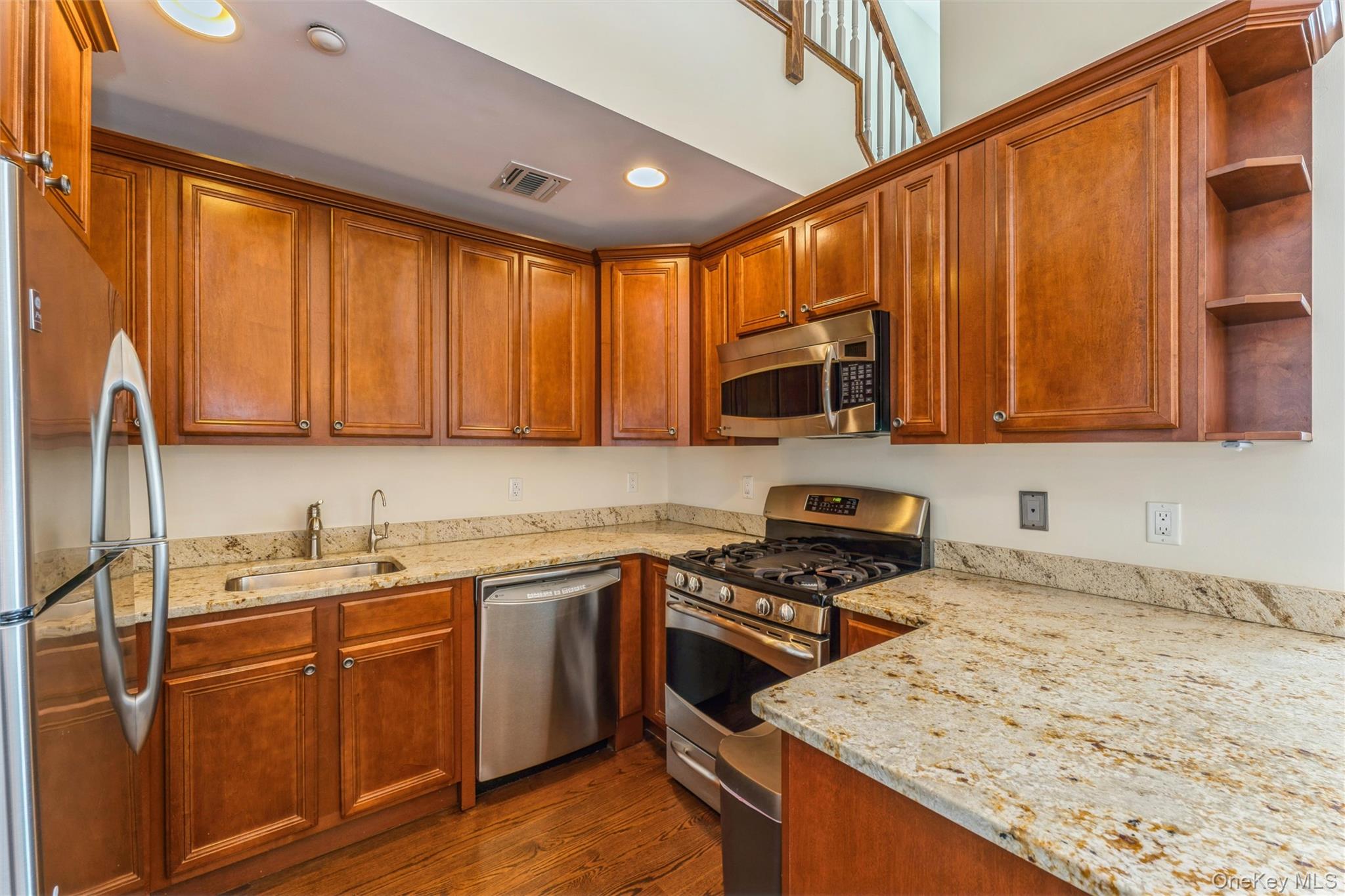 169 Spring Drive East Meadow, NY 11554 - Photo 6 of 33 a kitchen with stainless steel appliances granite countertop a stove a sink dishwasher and a microwave oven with wooden cabinets