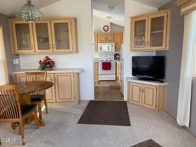 a living room with furniture a flat screen tv and kitchen view