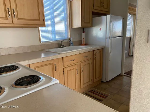 a kitchen with a refrigerator and white stove top oven