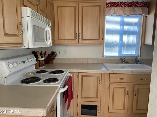 a kitchen with a sink a stove and cabinets