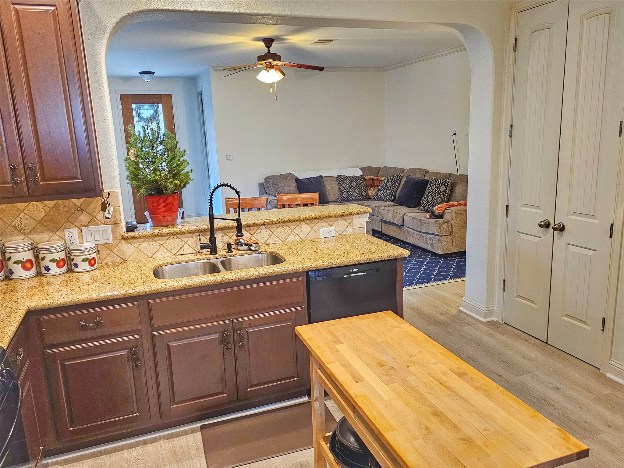 11508 Flushwing Drive Austin, TX 78754 - Photo 24 of 24 Kitchen with arched walkways, a peninsula, light stone countertops, open floor plan, and black dishwasher