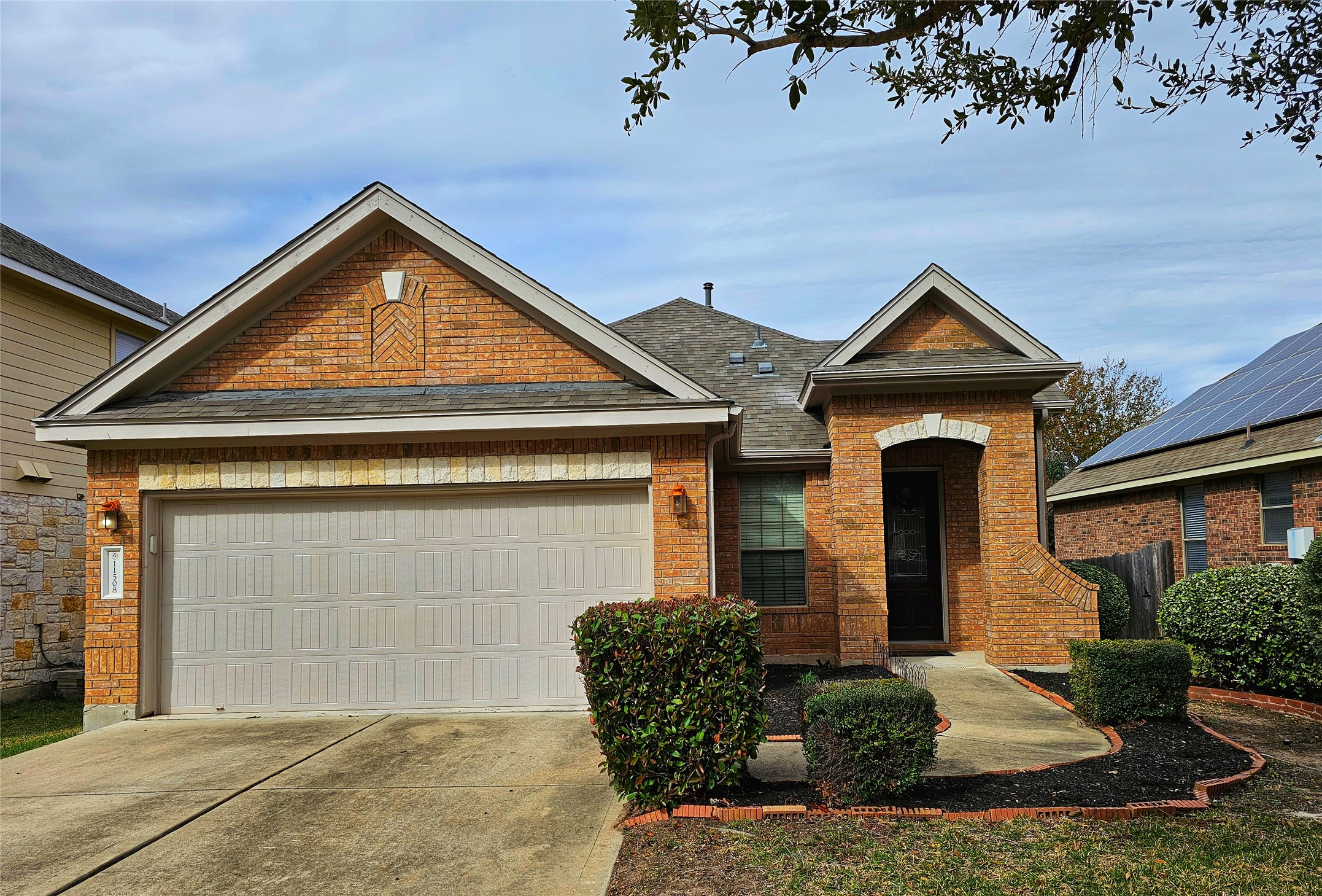 11508 Flushwing Drive Austin, TX 78754 - Photo 2 of 24 Craftsman-style home with driveway, a garage, brick siding, and roof with shingles