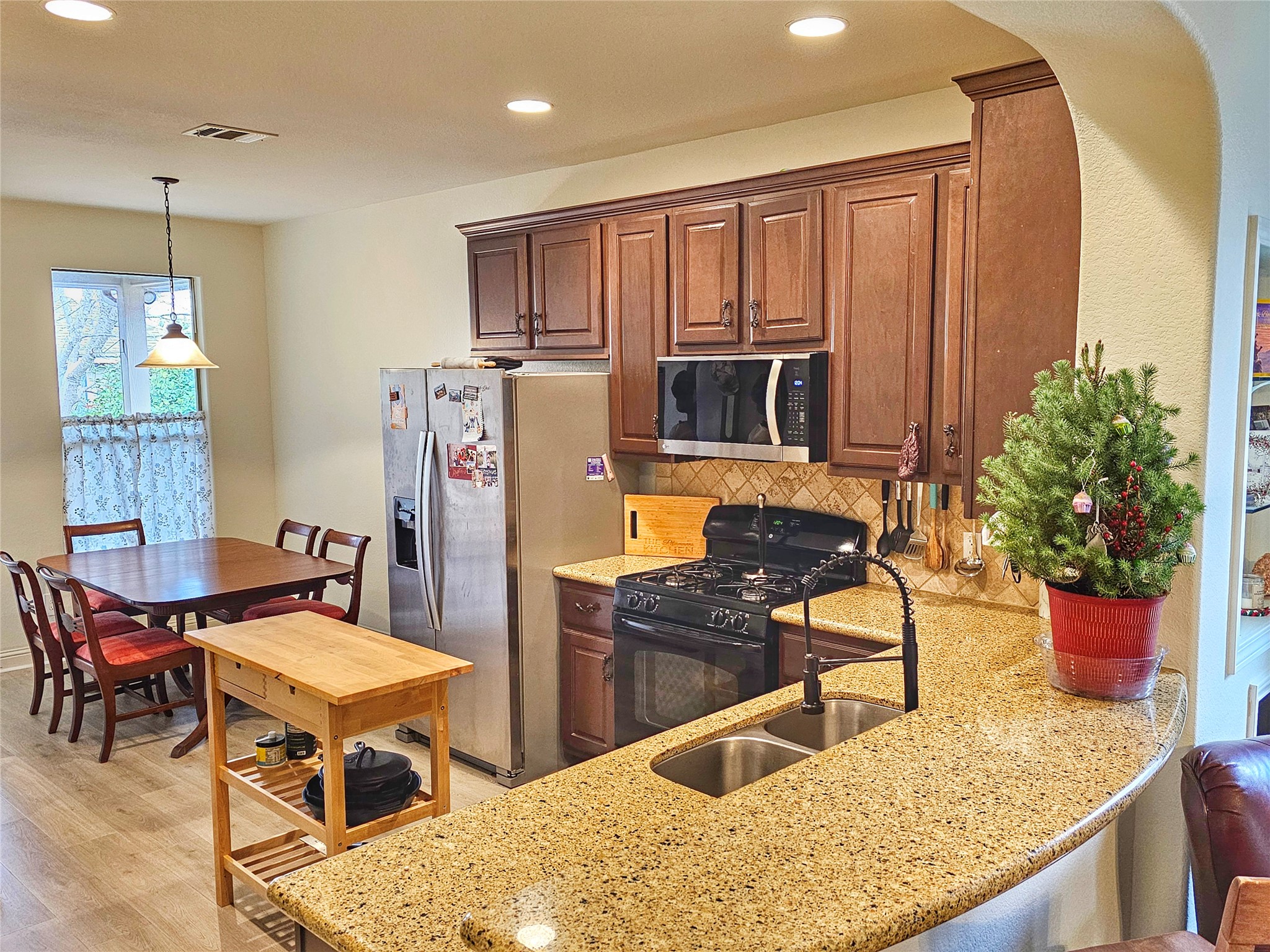 11508 Flushwing Drive Austin, TX 78754 - Photo 8 of 24 Kitchen featuring stainless steel appliances, light stone counters, tasteful backsplash, arched walkways, and recessed lighting