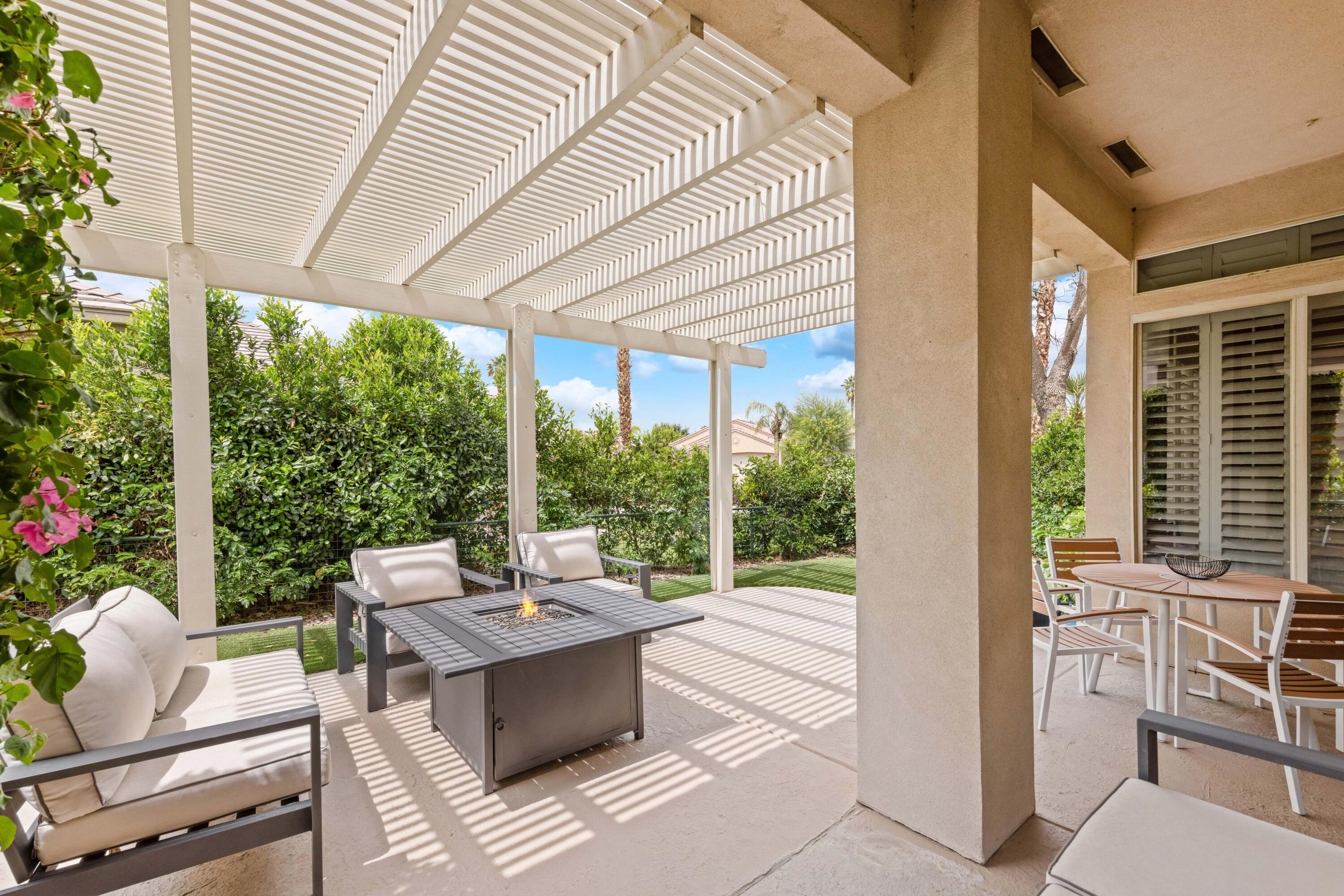 44357 Royal Lytham Drive Indio, CA 92201 - Photo 12 of 21 a outdoor space with the couches and dining table with the garden view
