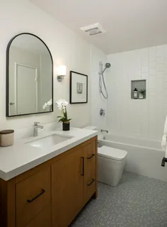 a bathroom with a toilet a sink a mirror and a bathtub