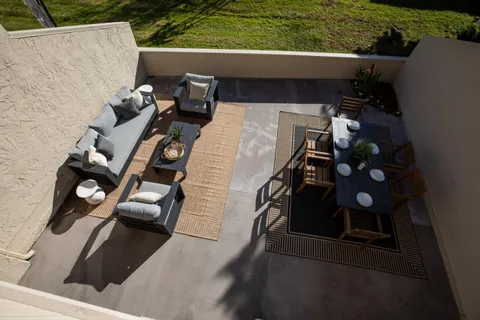 a view of a patio with table and chairs couches with wooden floor and fence