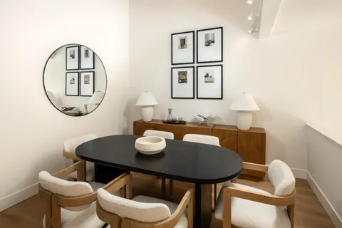 a view of a dining room with furniture and a mirror