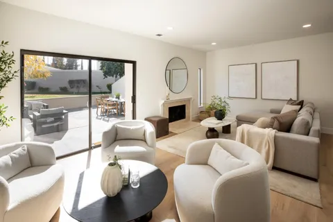 a living room with furniture a large window and a fireplace