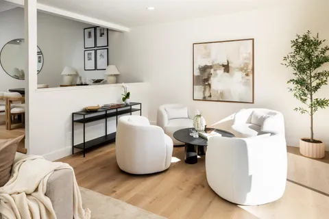 a living room with furniture and a painting on the wall