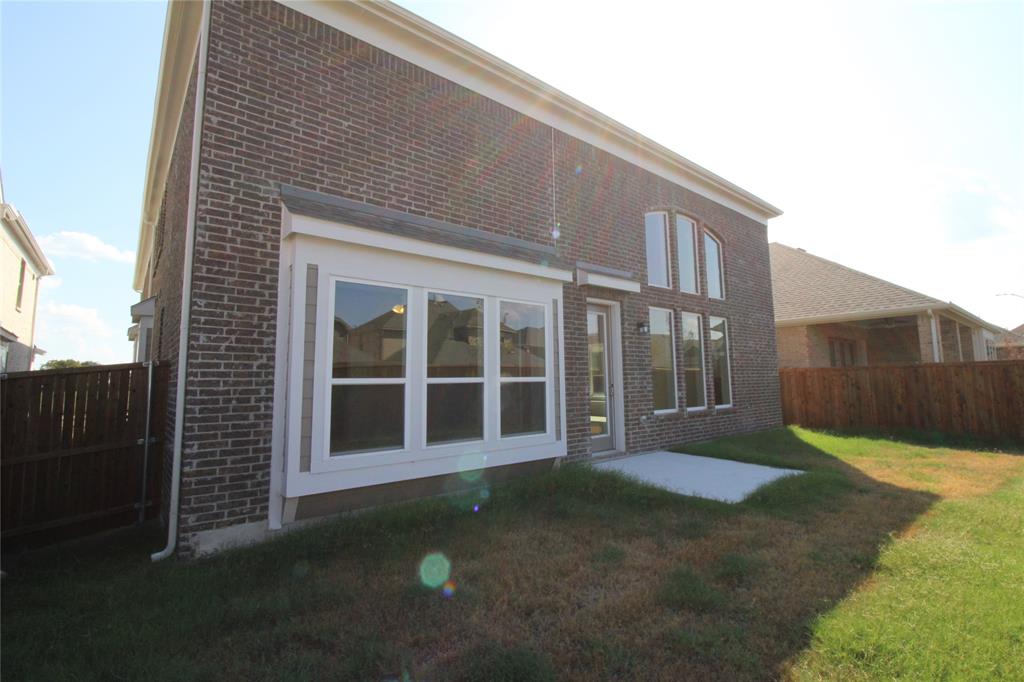 8407 Cornerstone Drive Rowlett, TX 75088 - Photo 1 of 25 Brick exterior featuring multiple large windows, a concrete patio, and a wood privacy fence