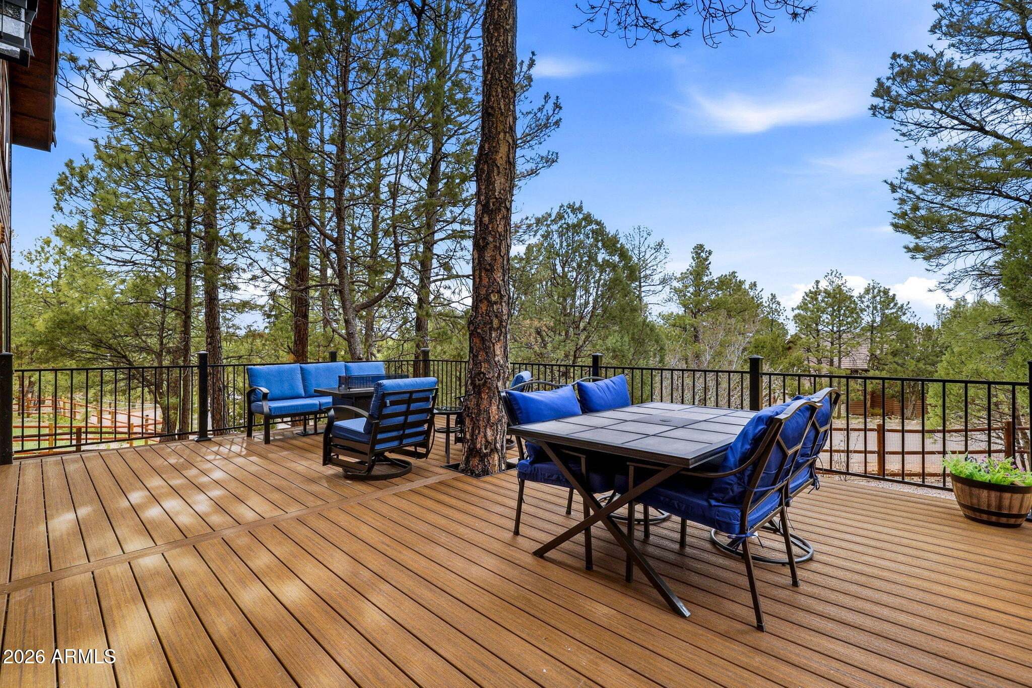 2287 Richenbacher Circle Overgaard, AZ 85933 - Photo 5 of 46 a view of a roof deck with table and chairs a barbeque with wooden floor and fence
