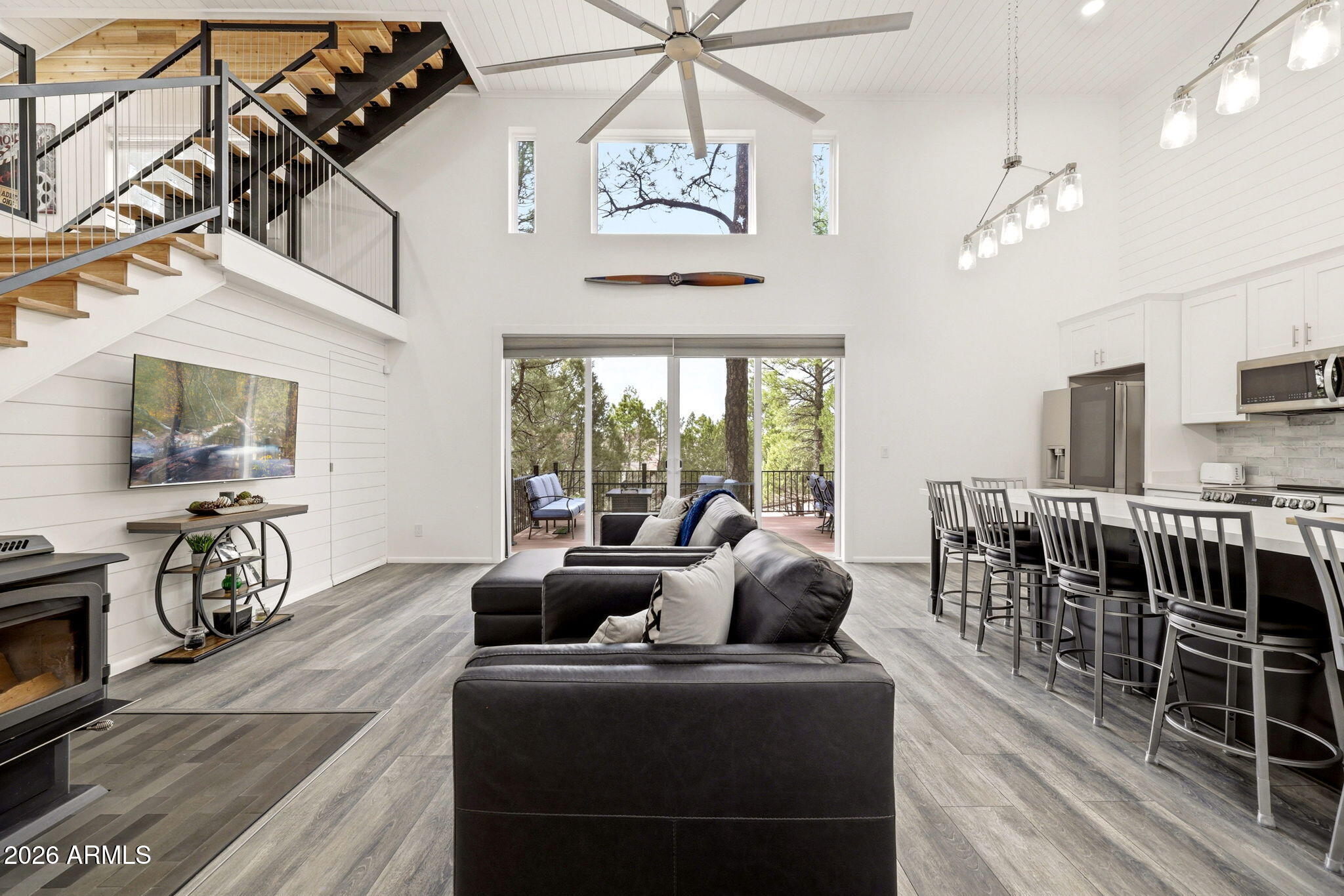 2287 Richenbacher Circle Overgaard, AZ 85933 - Photo 8 of 46 a living room with furniture a chandelier and a flat screen tv