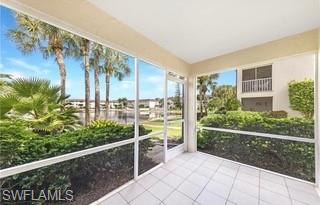 1018 Manatee Road, Unit E107 Naples, FL 34114 - Photo 11 of 15 Screened lanai featuring white tile flooring and direct outdoor access