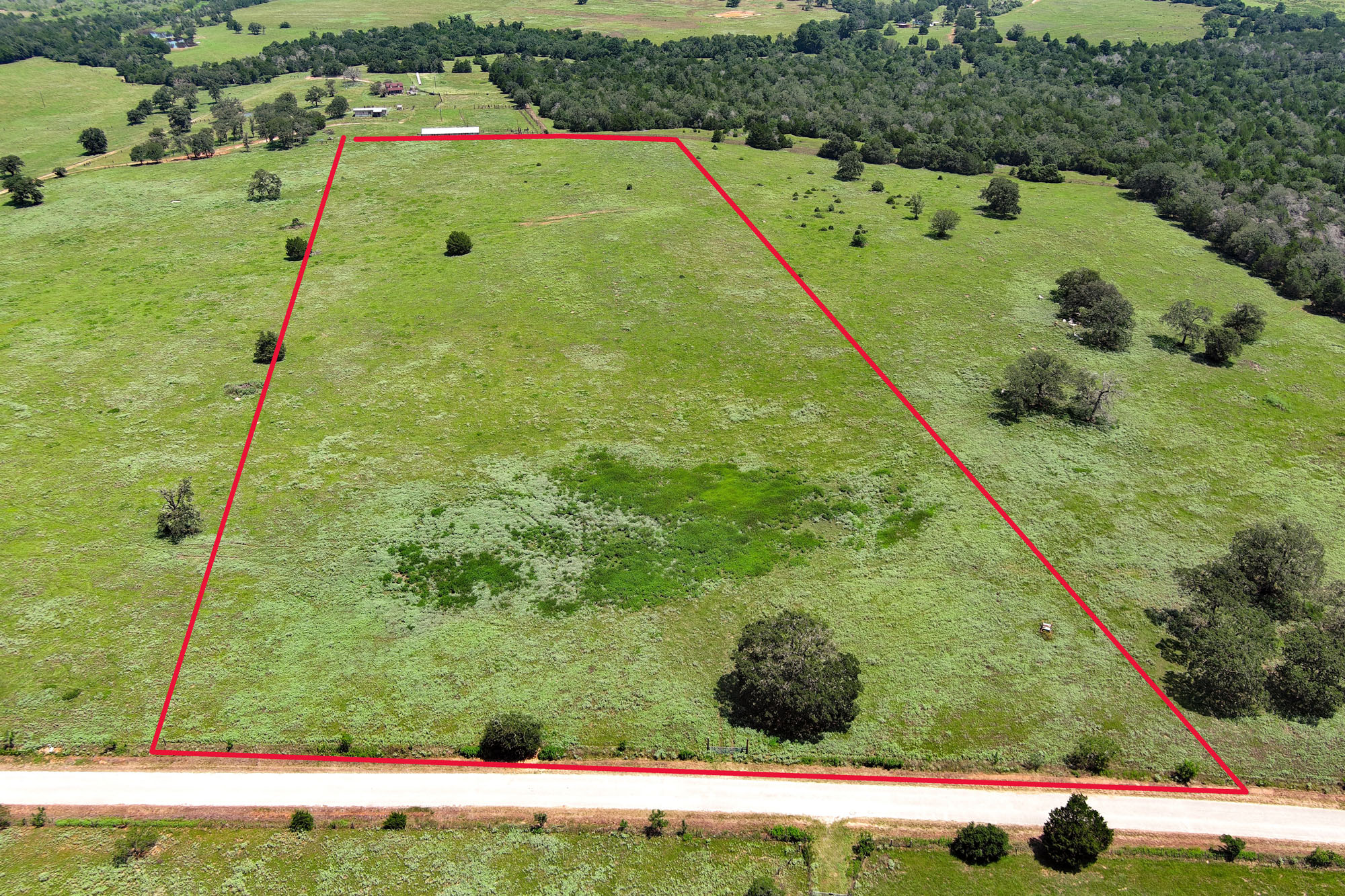 Tbd Hofferek Road Rosanky, TX 78953 - Photo 2 of 32 A verdant parcel of land awaits your vision, featuring a blend of open fields and scattered mature trees.