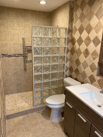 a bathroom with a sink a toilet and shower