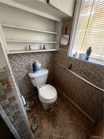 a bathroom with a toilet and a window